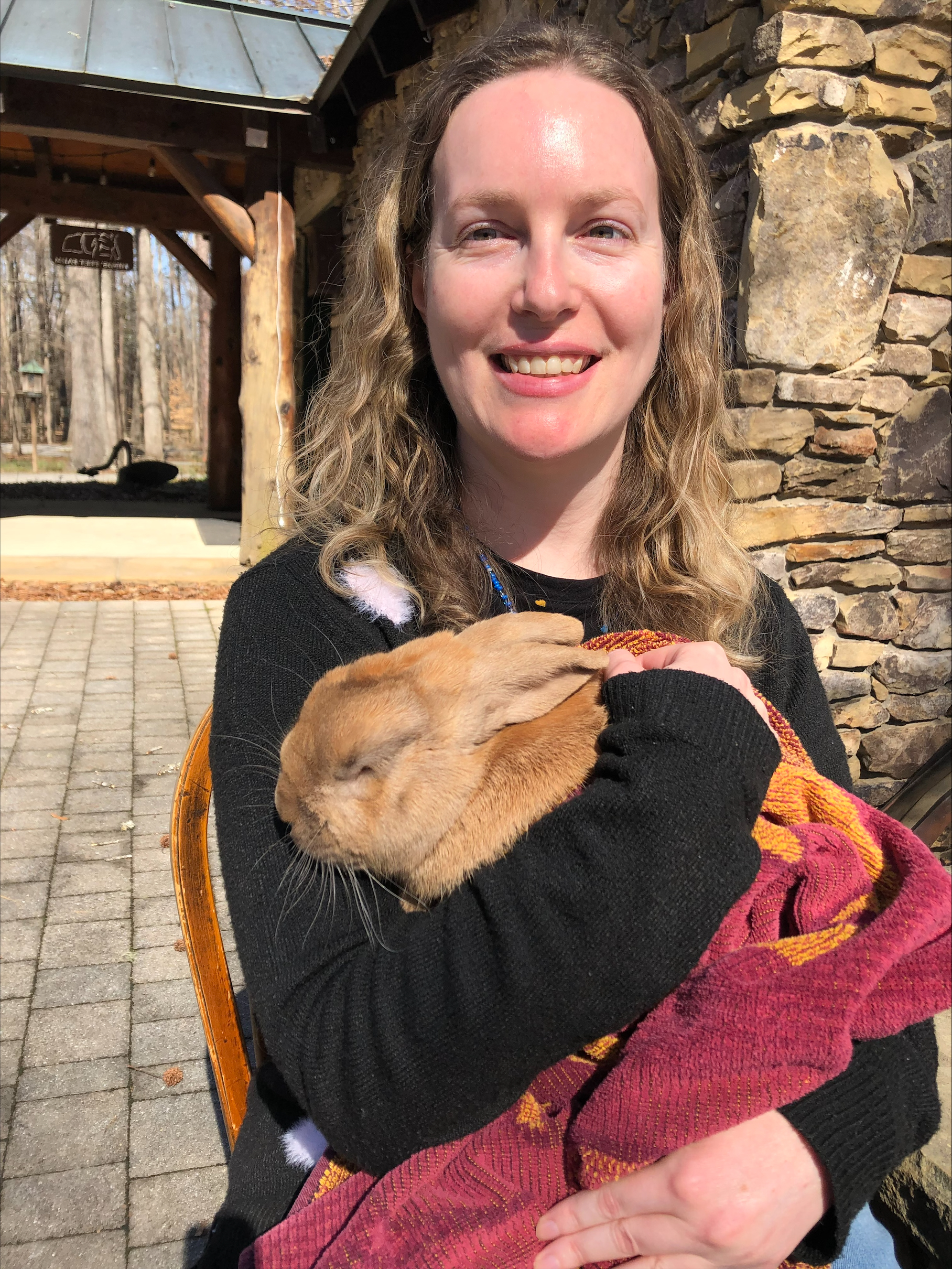 blonde woman holding a brown rabbit