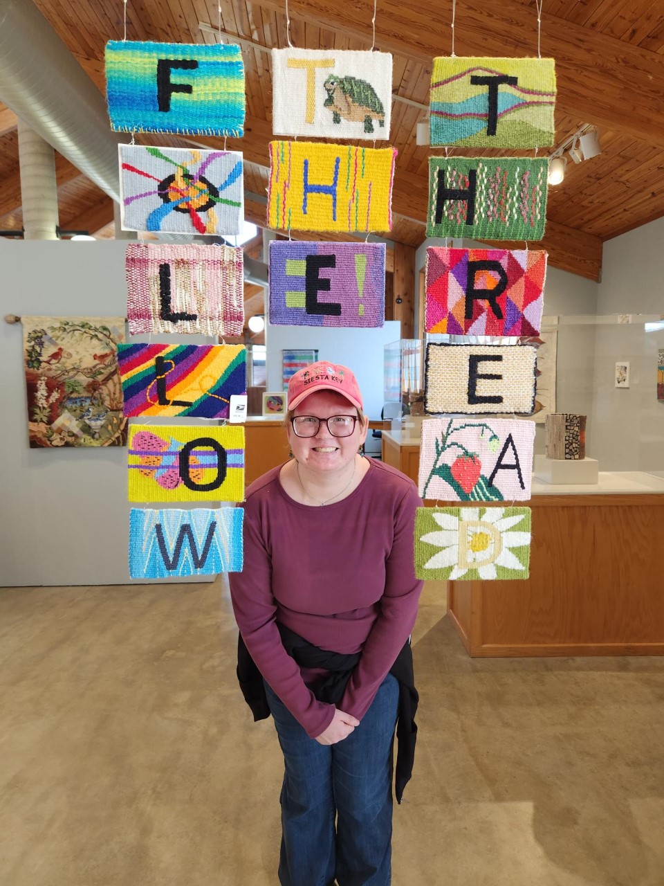 woman standing in front of fabric art in a gallery